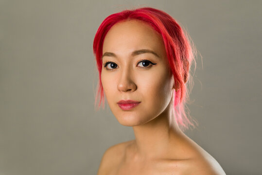 Portrait Of An Asian Woman With Creative Hair Coloring Bright Red, Pink. Beautiful Young Girl With Scarlet Hair Close Up