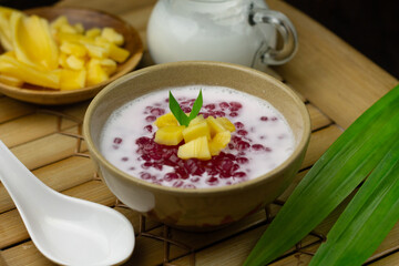 Bubur Mutiara or Sago pearls porridge,Indonesian popular traditional dessert made from sago pearls and coconut milk, served on ceramic bowl, topping with jackfruit slices garnished with pandan leaves.