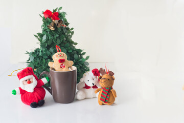 Fototapeta na wymiar Christmas decorations next to Santa Claus have fun and play in a cup around a Christmas tree in the prosperity of the new year with white background.