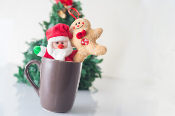 fun christmas cookies hugging santa claus inside a cup with the Christmas tree behind very funny