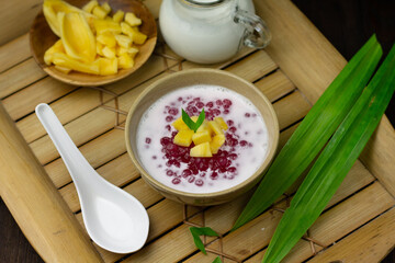 Bubur Mutiara or Sago pearls porridge,Indonesian popular traditional dessert made from sago pearls and coconut milk, served on ceramic bowl, topping with jackfruit slices garnished with pandan leaves.