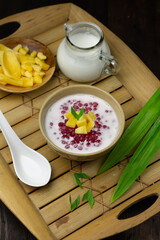 Bubur Mutiara or Sago pearls porridge,Indonesian popular traditional dessert made from sago pearls and coconut milk, served on ceramic bowl, topping with jackfruit slices garnished with pandan leaves.