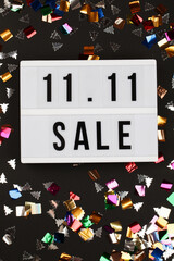 11.11 sale text on white lightbox with confetti on black background.