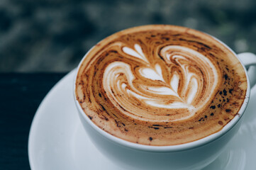 A Cup of hot latte art coffee on wooden table