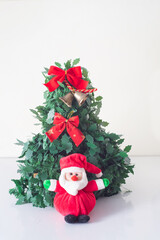 Some dolls like reindeer bears cookies and christmas decorations next to santa claus have fun around a christmas tree in the prosperity of the new year in white background