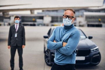 Two men in protective masks on the runway