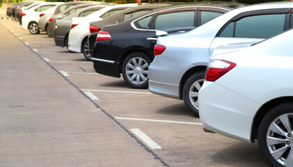Closeup of rear or back side of white car and other park in outdoor parking area in sunny day. 