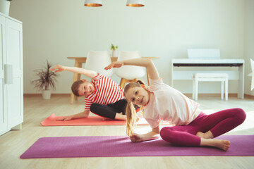 Happy children making yoga at home dueing coronavirus quarantine