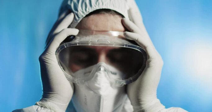 Medico stanco con tuta covid si mette le mani in testa