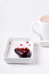Marshmallow popsicle with strawberry and chocolate glazing and a cup of coffee with foam against the white background. Dessert for Valentines day