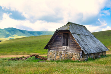 Fototapeta na wymiar Amazing green field, pastures, mountain road and small farmer hut in the hills of Zlatibor resort in Western Serbia