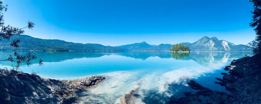 Der t&uuml;rkisblaue Walchensee und die Insel Sassau im morgendlichen Licht als Panorama mit Karibikflair