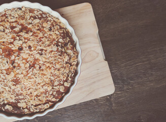 Fresh baked golden apple pie in red dish at kitchen