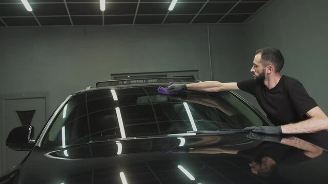 Professional Car Ceramics Worker applies a layer of ceramics protective rain cover on car windows. Concept from: Nano Protection, Different accessories, Long protection