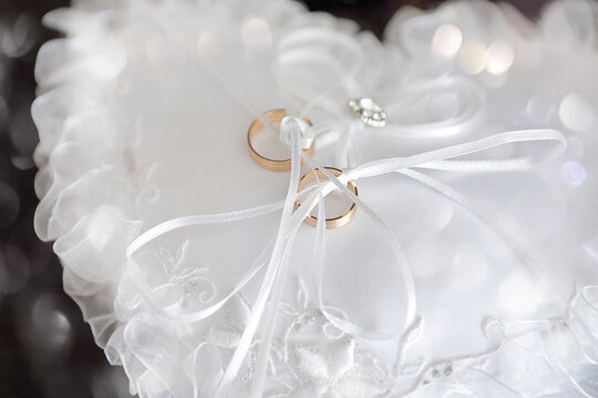 Gold wedding rings on a satin pillow