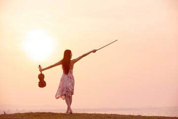 woman playing violin at sunset background © ittipol