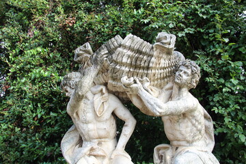 Obraz premium Statue of two men carrying a big load.