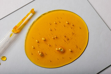 Yellow viscous liquid lecithin with bubbles on glass