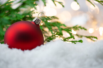 Czerwona dekoracja na Boże Narodzenie, bombka i gałązka choinki na śniegu