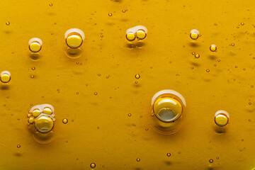 Yellow viscous liquid lecithin with bubbles on glass