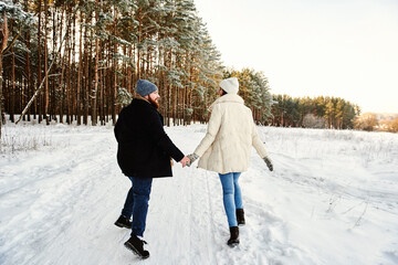Funny couple emotionally runs in the winter woods. Full-length Horizontal Back View