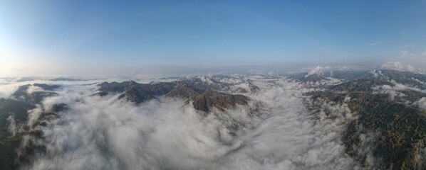 Panoramic landscape above mountains with sun rising.