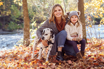 girl and her daughter and Dalmatians dog in a park in autumn