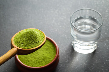 Wheat grass powder and glass of water .