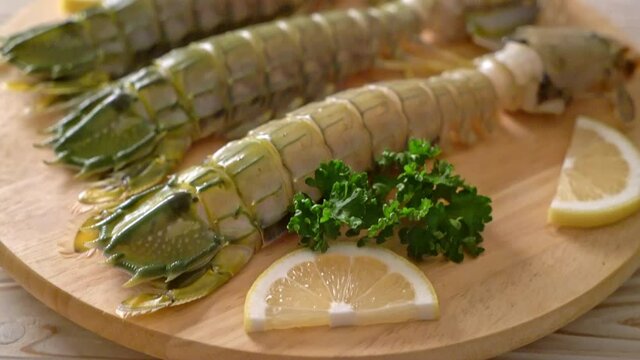 fresh mantis shrimp with lemon on wood board