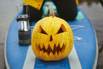 pumpkin on inflatable Board with paddle, sup surfing in autumn