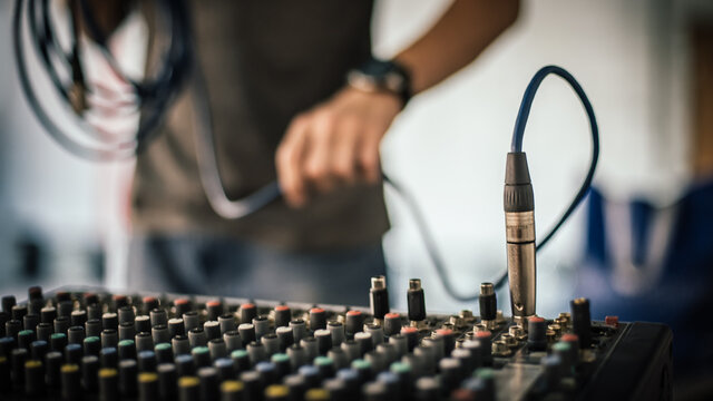 Behind the scene. Sound technician electric engineer adjusting sound elements backstage. Control audio panel. Audio mixing console