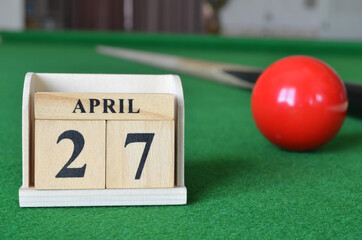 April 27, number cube with balls on snooker table, sport background.