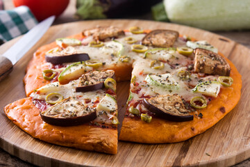 Autumn pumpkin pizza with vegetables on wooden table.	