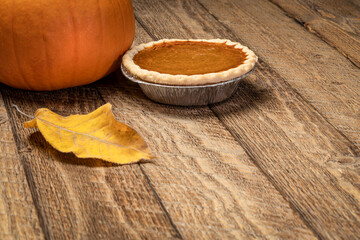 pumpkin pie and pumpkin on a rustic wooden table, Thanksgiving and fall holidays concept