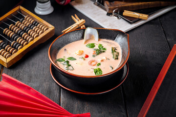 Asian seafood soup in a black bowl