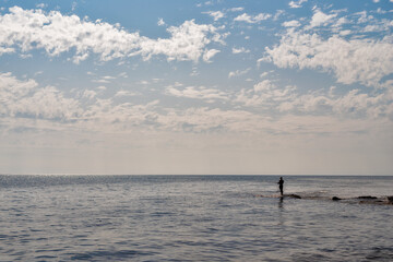 Fototapeta na wymiar Silhouette of a fisherman fishing in the open sea.