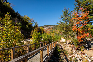 A walkway near Lower Falls along the Kancamagus Highway, New Hampshire with colorful autumn foliage.

