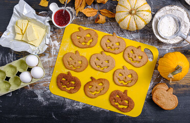 woman making cookies for halloween celebration at home with ginger dough and strawberry jam