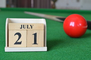 July 21, number cube with balls on snooker table, sport background.