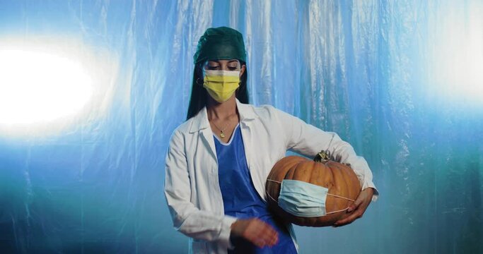 Giovane medico donna fa compagnia con la zucca di Halloween 