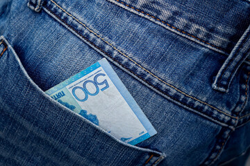 Kazakhstani tenge in the back pocket of jeans. Five hundred tenge in a denim pocket.