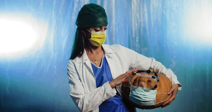 Giovane medico donna fa compagnia con la zucca di Halloween 