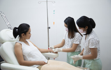 Asian woman receiving vitamin IV infusion or chemotherapy drip in hospital or beauty salon. Healthcare, wellness and medicine concept