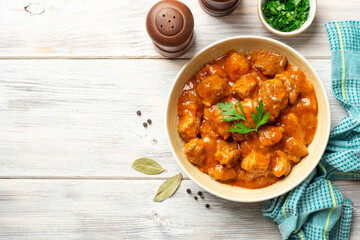 Meat stew in bowl on rustic wooden background