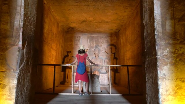 A young woman visiting the inner rooms inside the temple of Abu Simbel, in southern Egypt in Nubia next to Lake Nasser. Temple of Pharaoh Ramss II, 4k video