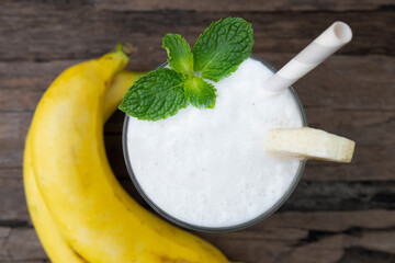 Banana fresh cocktail vanilla smoothies  fruit juice beverage healthy the taste yummy in glass drink episode good morning on wooden background from the top view.