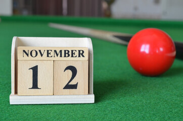 November 12, number cube with balls on snooker table, sport background.