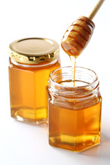 白バックで撮影したガラスボトルのハチミツとハチミツディッパー