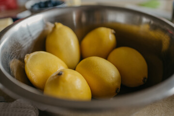 Lemons in the stainless steel soup bowl in the kitchen.