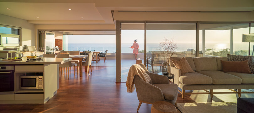 Woman enjoying scenic sunny ocean view on luxury balcony